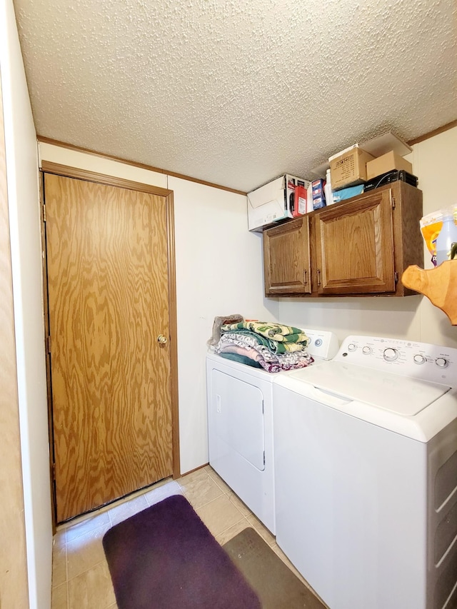 laundry room with cabinets, washing machine and clothes dryer, and crown molding