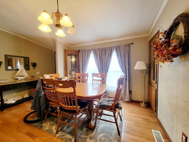 dining area featuring light hardwood / wood-style flooring, an inviting chandelier, and crown molding