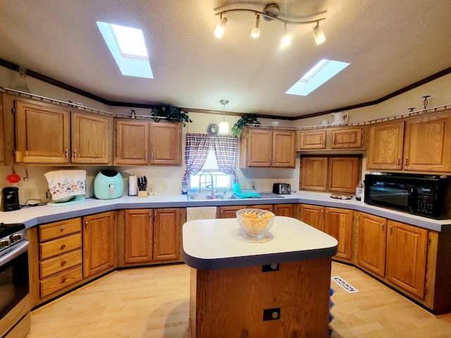 kitchen with decorative light fixtures, a kitchen island, crown molding, and light hardwood / wood-style flooring