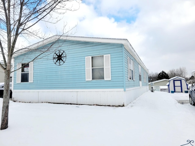 view of snow covered exterior featuring a storage shed