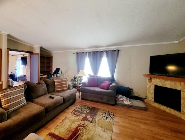 living room with lofted ceiling, a fireplace, ornamental molding, and hardwood / wood-style floors