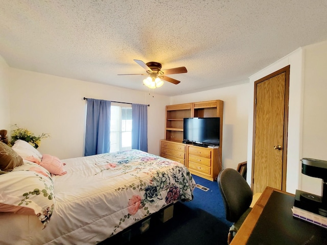 carpeted bedroom with a textured ceiling and ceiling fan