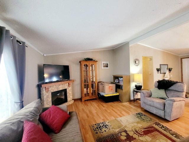 living room featuring lofted ceiling, a fireplace, hardwood / wood-style floors, and ornamental molding