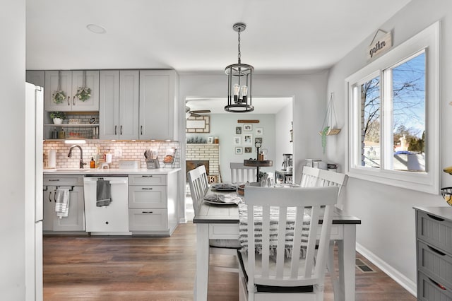 kitchen with white dishwasher, tasteful backsplash, pendant lighting, and gray cabinets