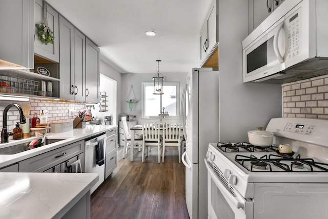 kitchen featuring white appliances, decorative light fixtures, tasteful backsplash, sink, and gray cabinets