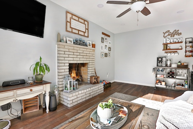 living room featuring a brick fireplace, dark hardwood / wood-style flooring, and ceiling fan