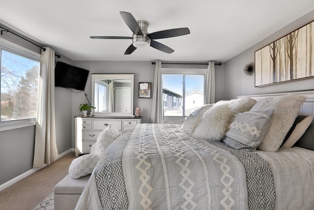 bedroom with ceiling fan, light carpet, and multiple windows