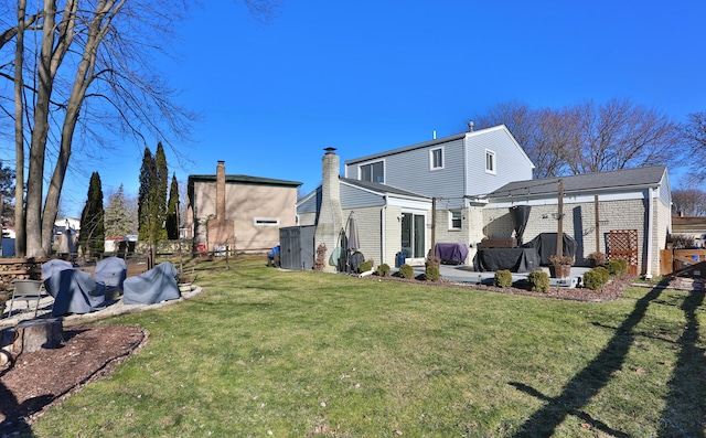 back of property with a patio area and a lawn