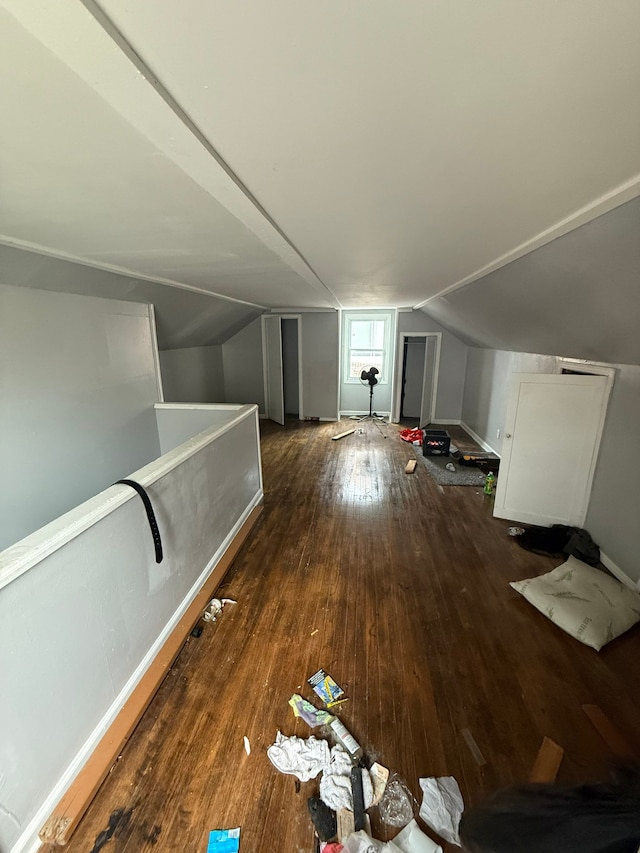 bonus room with dark hardwood / wood-style flooring and vaulted ceiling