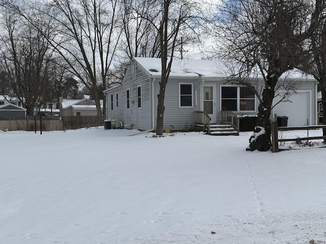 single story home featuring cooling unit and a garage