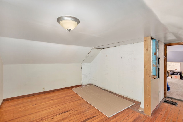 additional living space featuring lofted ceiling and light hardwood / wood-style floors