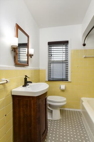 full bathroom with toilet, vanity, tile walls, and tile patterned floors