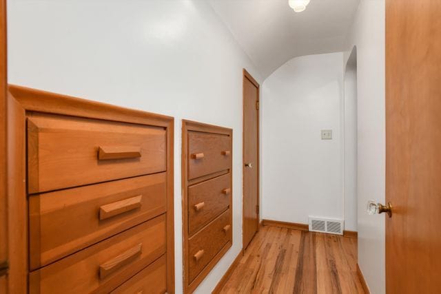 hall featuring lofted ceiling and light wood-type flooring