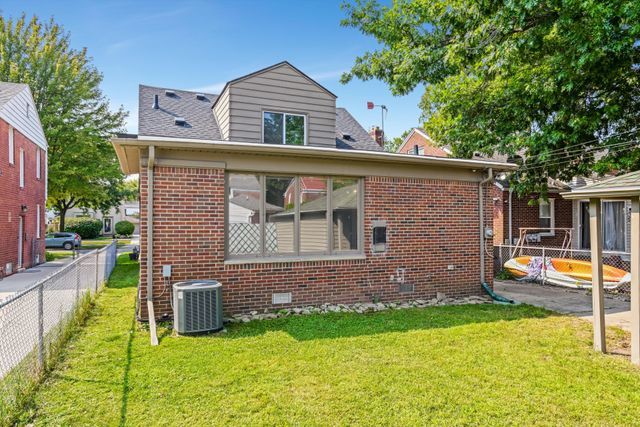 back of property featuring central AC and a yard