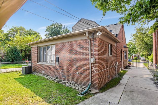 view of side of home with central AC unit and a yard