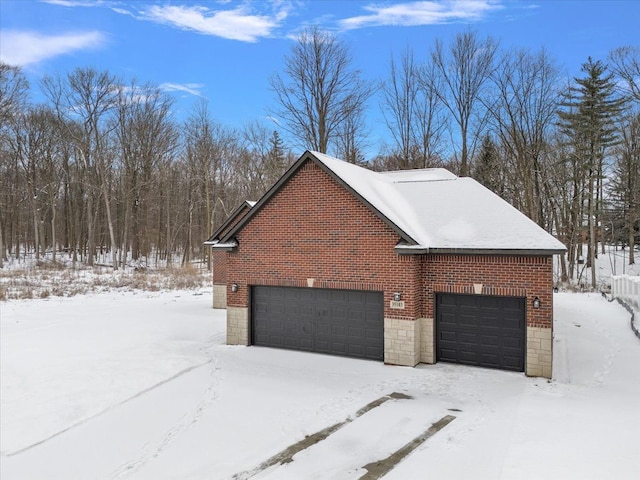 snow covered property with a garage