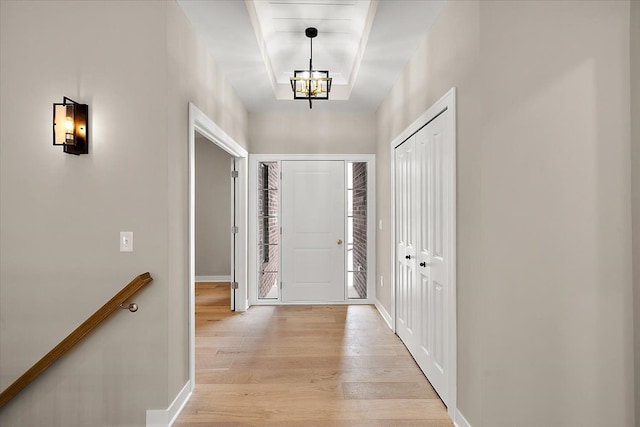 foyer with light hardwood / wood-style flooring and an inviting chandelier