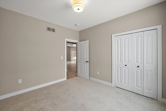 unfurnished bedroom with a closet and light carpet