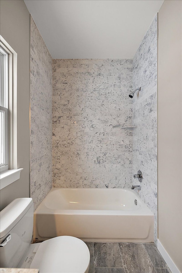 bathroom featuring toilet and tub / shower combination