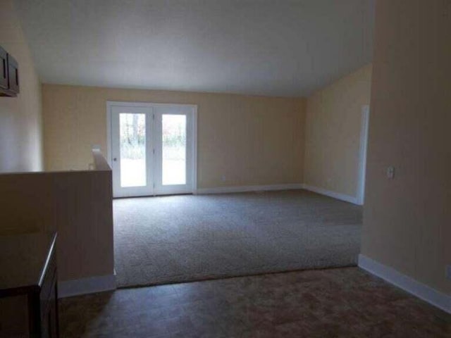 carpeted spare room featuring french doors