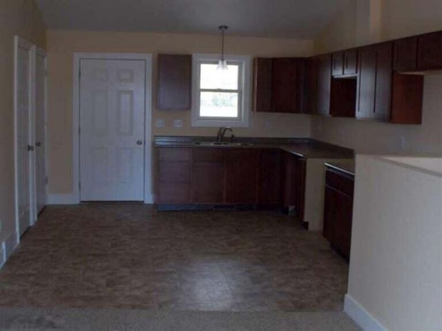 kitchen with sink, lofted ceiling, and hanging light fixtures