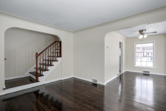 21746-48 Moross Rd, Grosse Pointe, MI 48236 - unfurnished room featuring arched walkways, wood-type flooring, ceiling fan, stairs, and baseboards