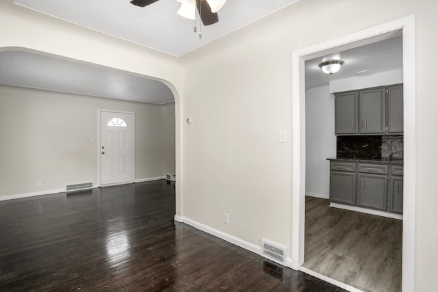 21746-48 Moross Rd, Grosse Pointe, MI 48236 - spare room with arched walkways, a ceiling fan, dark wood-style flooring, and baseboards