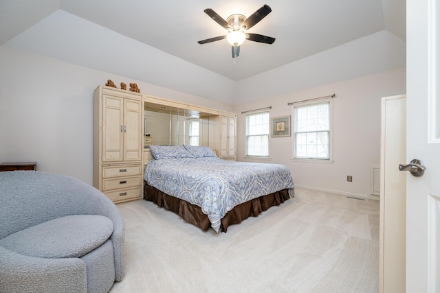 carpeted bedroom featuring ceiling fan and a tray ceiling