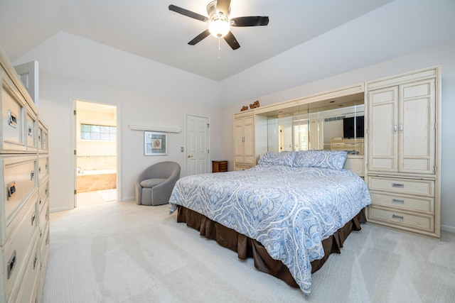 bedroom with lofted ceiling, connected bathroom, light carpet, and ceiling fan