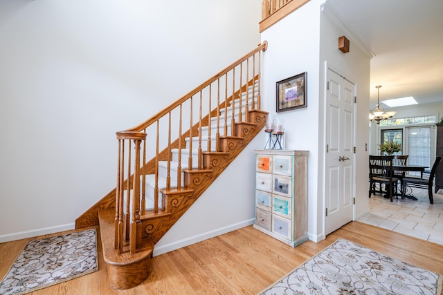 stairway featuring an inviting chandelier and wood-type flooring