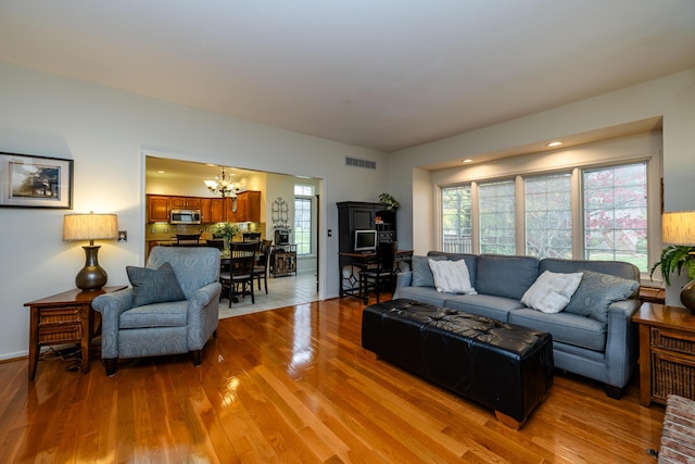 living room featuring light hardwood / wood-style floors and a chandelier