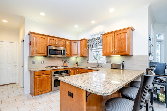 kitchen featuring sink, a breakfast bar area, kitchen peninsula, and appliances with stainless steel finishes