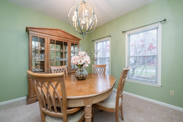 carpeted dining area featuring a chandelier