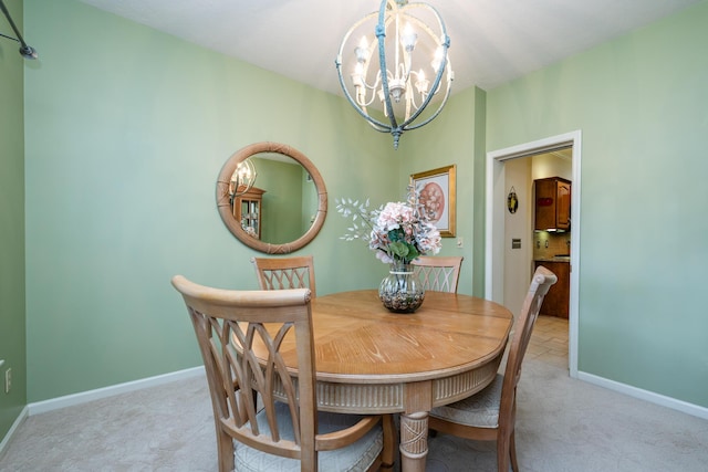 dining area with light carpet and a chandelier