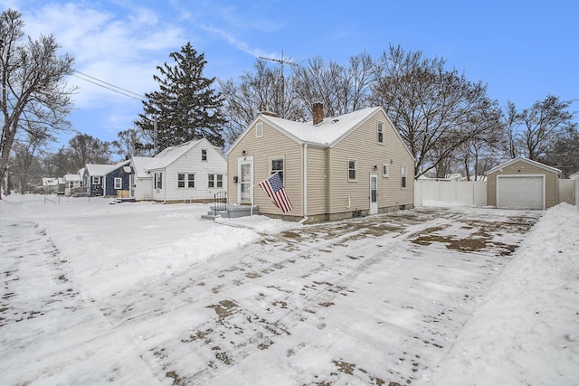 view of snow covered exterior with a garage and an outdoor structure