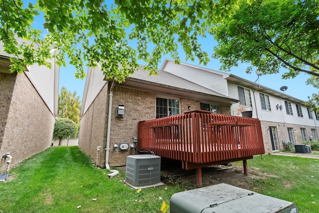 rear view of house with a lawn, a deck, and central air condition unit