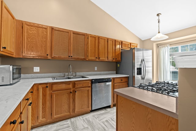 kitchen with pendant lighting, sink, lofted ceiling, and appliances with stainless steel finishes