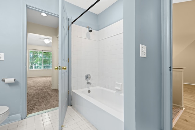 bathroom with tiled shower / bath, toilet, and tile patterned flooring