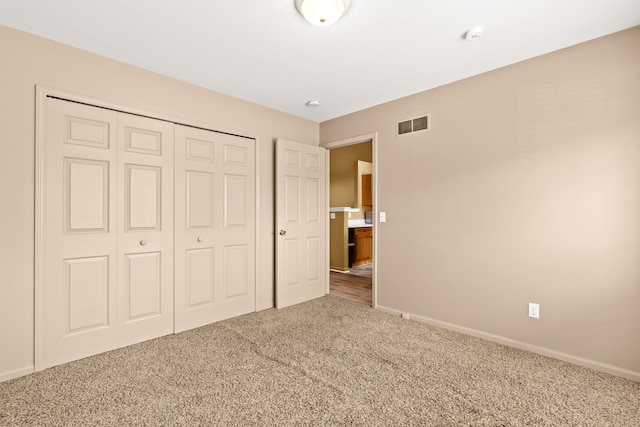 unfurnished bedroom featuring carpet and a closet