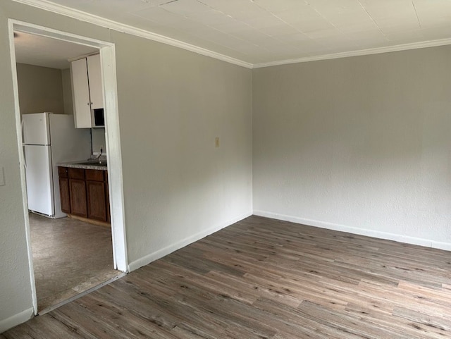 spare room with light wood-type flooring and ornamental molding