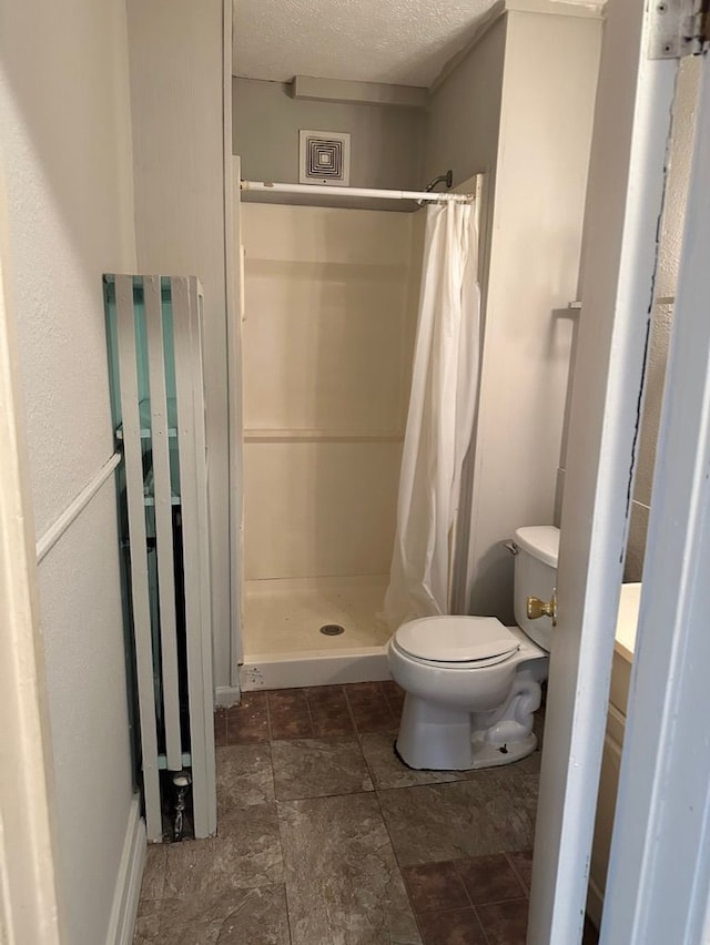 bathroom featuring a textured ceiling, vanity, curtained shower, and toilet