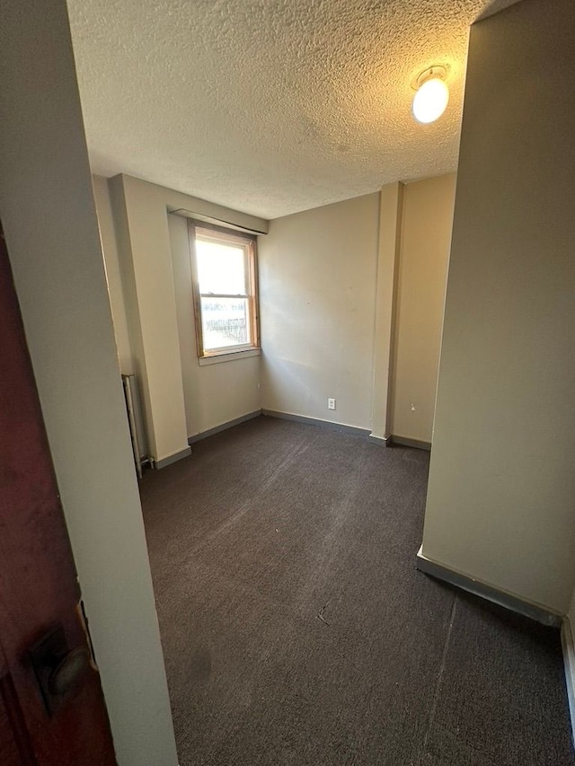 carpeted spare room featuring a textured ceiling