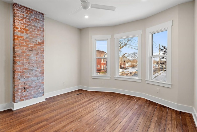 spare room with a ceiling fan, baseboards, and wood finished floors