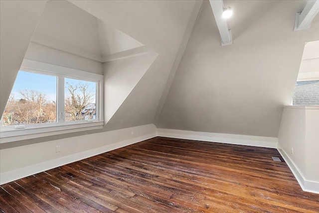 unfurnished room featuring lofted ceiling, baseboards, and dark wood-type flooring