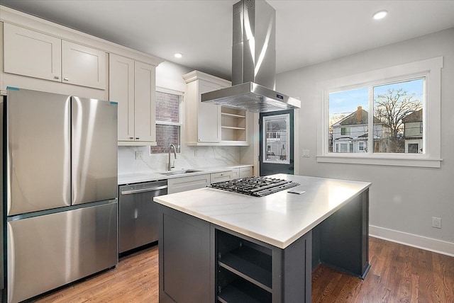 kitchen featuring white cabinets, a kitchen island, island exhaust hood, stainless steel appliances, and light countertops