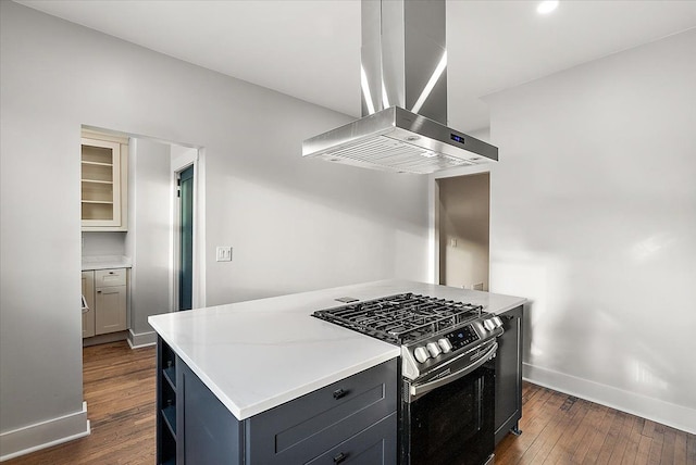 kitchen with island exhaust hood, baseboards, dark wood finished floors, and stainless steel range with gas stovetop