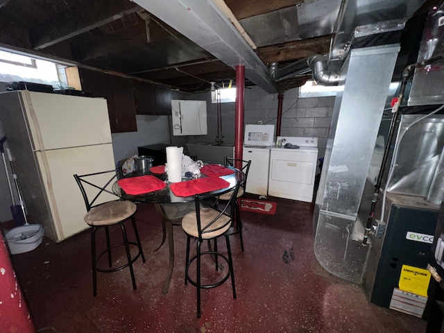 basement featuring washer and dryer and white refrigerator