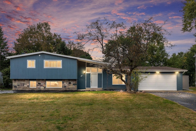 view of front of house featuring a garage and a lawn