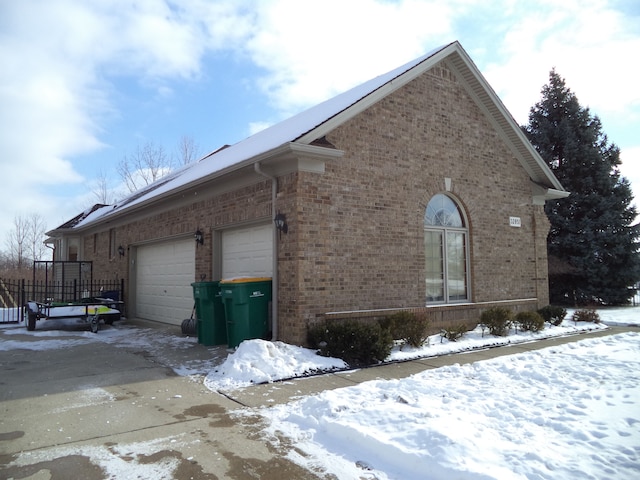 snow covered property featuring a garage