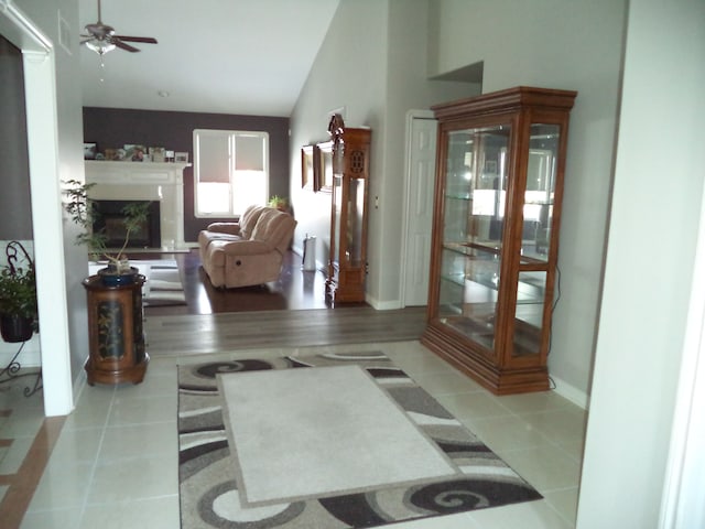 interior space with ceiling fan, light tile patterned floors, and vaulted ceiling